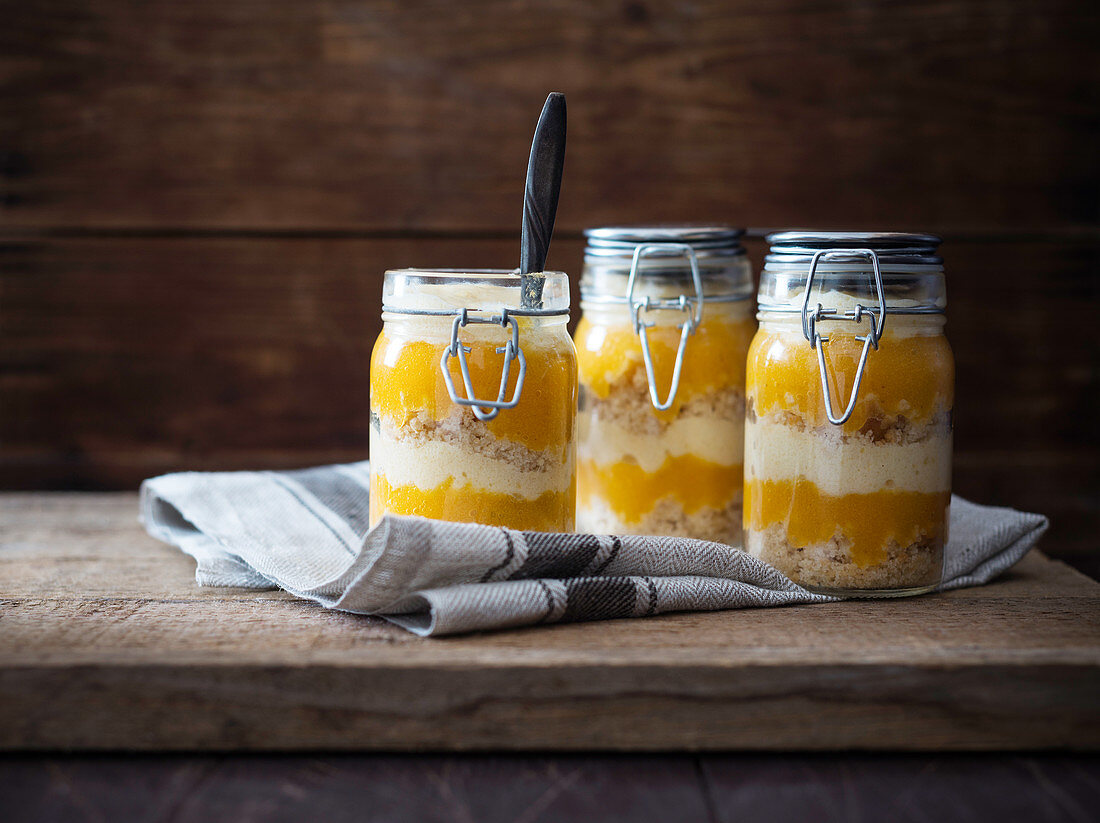 Vegan desserts in jars made with cake, mango purée and vanilla semolina cream
