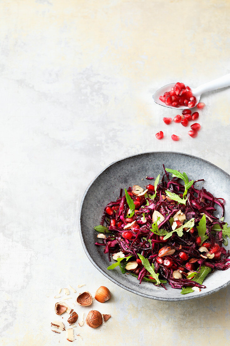 Red cabbage salad with rocket, pomegranate seeds and nuts