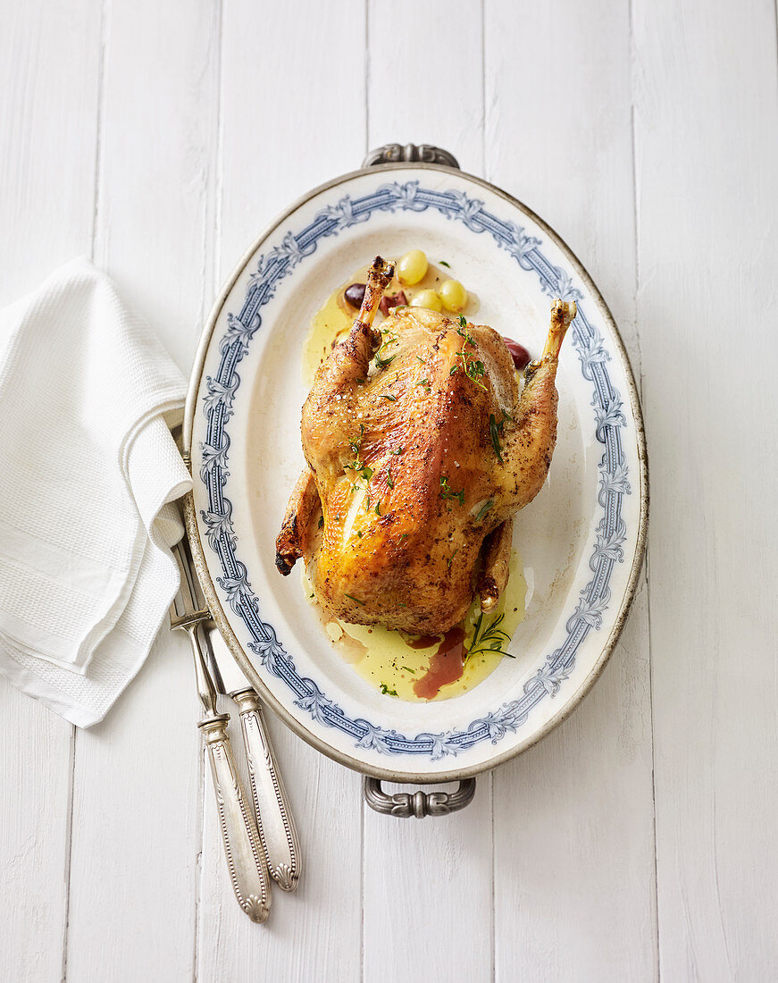 A roast chicken stuffed with grapes and olives