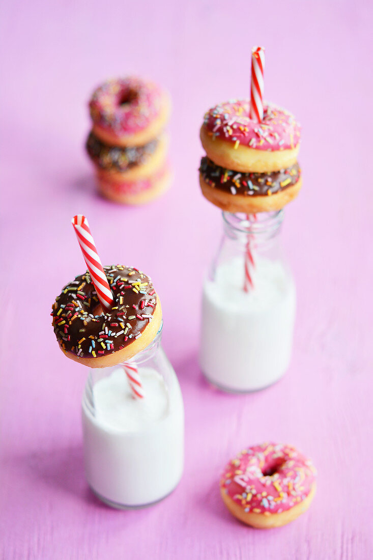 Mini doughnuts with icing and sugar strands, and vegan milk in bottles