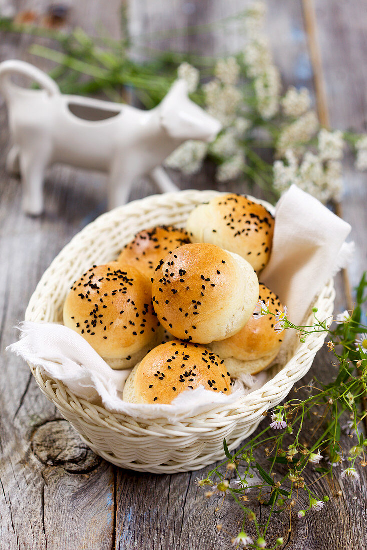 Bread rolls with black sesame seeds in a bread basket