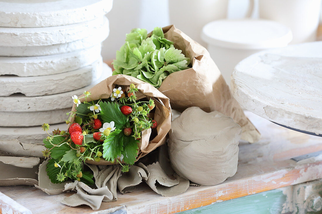 Bouquet of strawberry plants wrapped in paper in potter's workshop