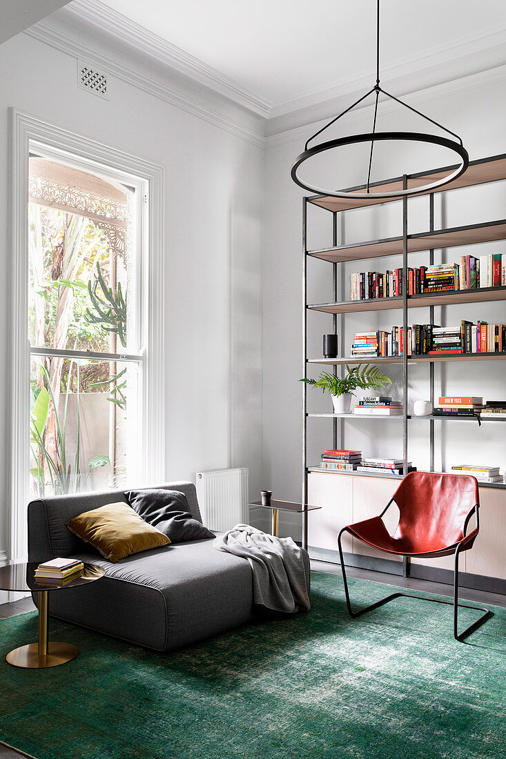 Gray upholstered sofa, leather chair and open shelf in the living room