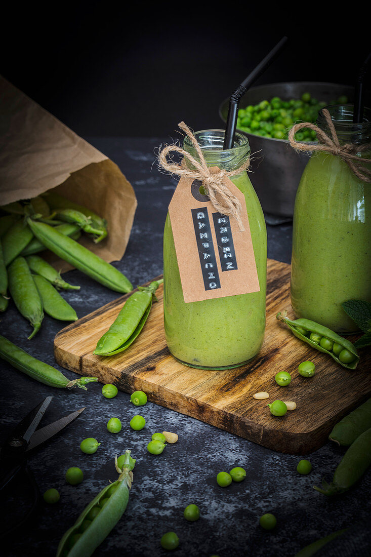 Cold pea soup in small glass bottles with straws