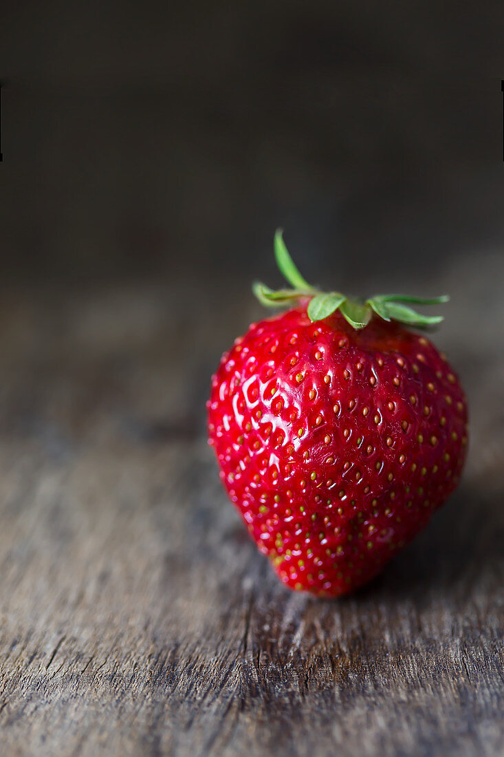 Fresh strawberry on a dark wooden surface