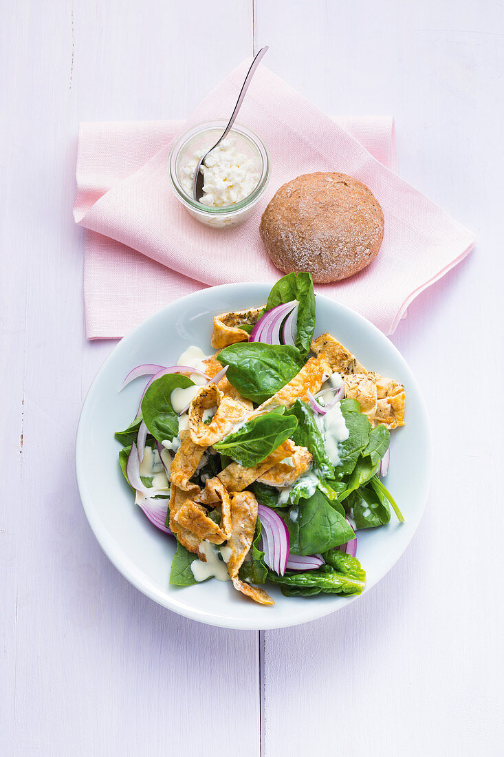 Spinach salad with red onions and omelette strips