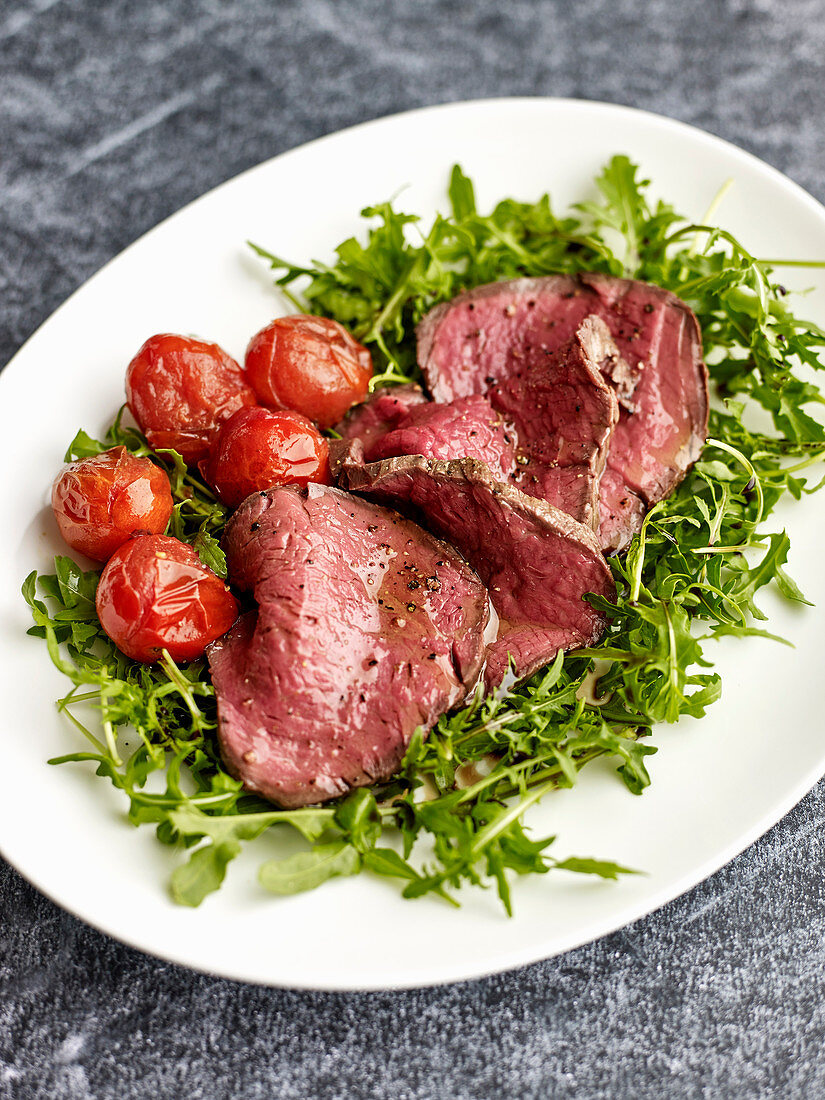 Tagliata di Manzo (beef fillet on a bed of rocket with cocktail tomatoes, Italy)