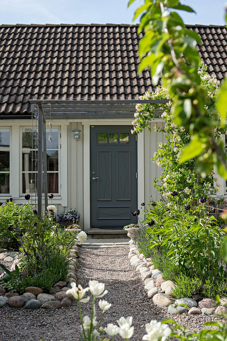 Kiesweg mit Steinbegrenzung im ländlichen Garten