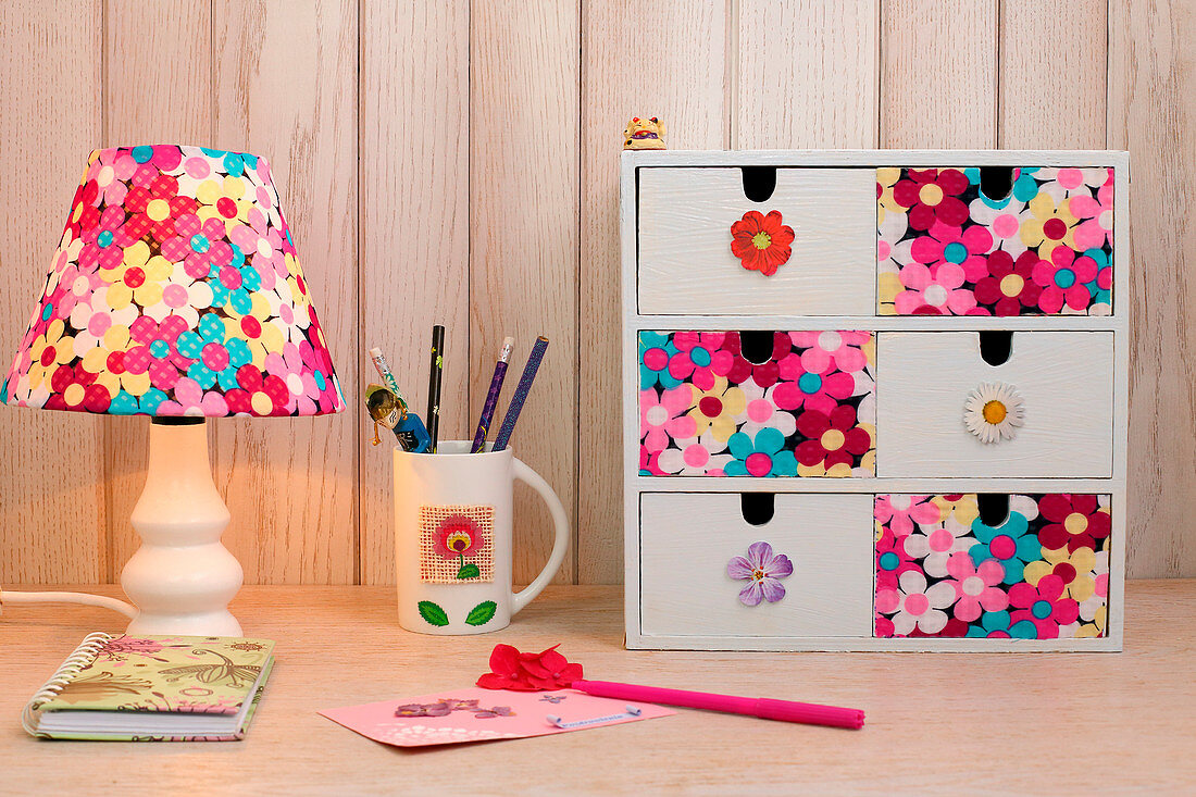 Table lamp and small set of drawers decorated with floral fabric