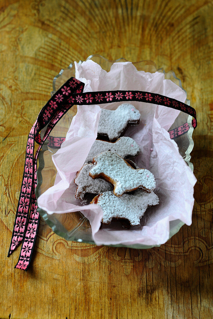 A basket of Easter lamb biscuits with icing sugar