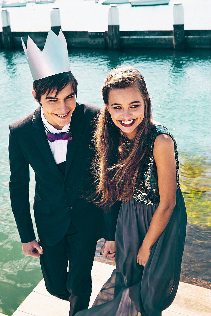 A girl wearing an elegant black dress and a boy wearing a black suit and a crown