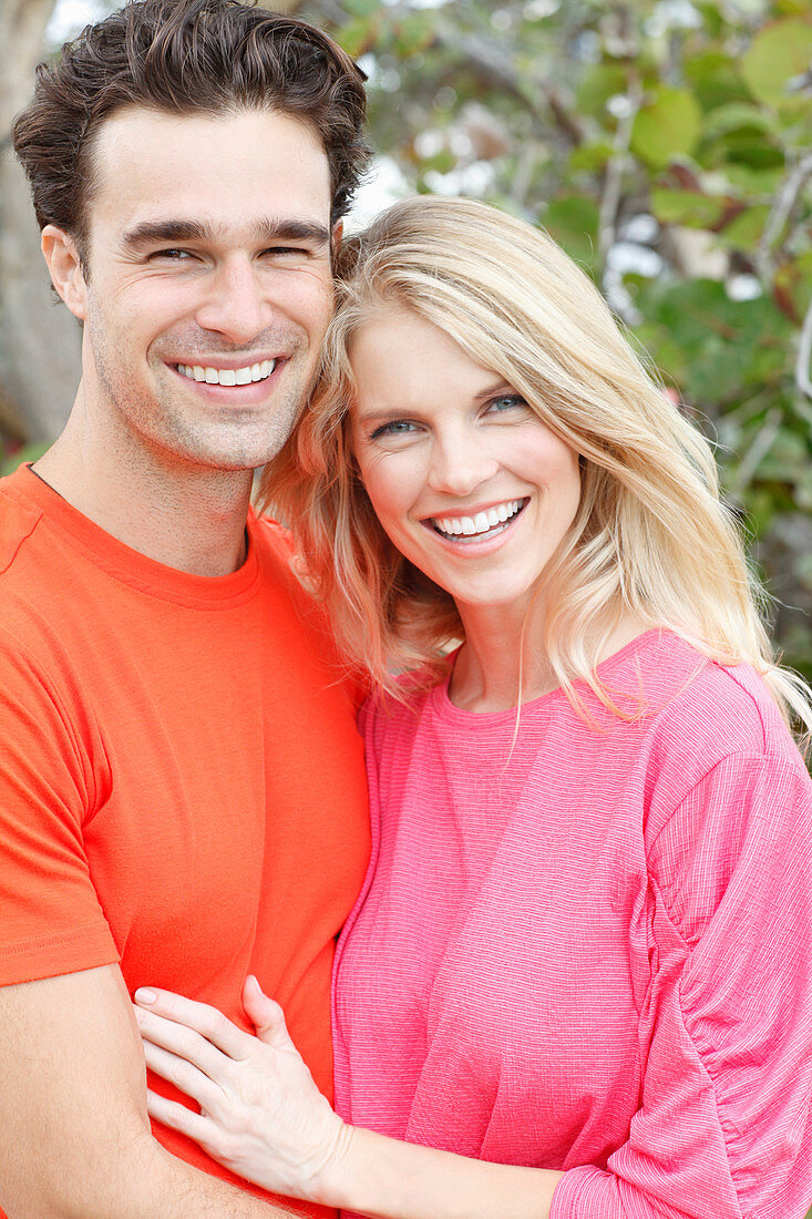 Blonde Frau in rosa Bluse und brünetter Mann in orangefarbenem T-Shirt