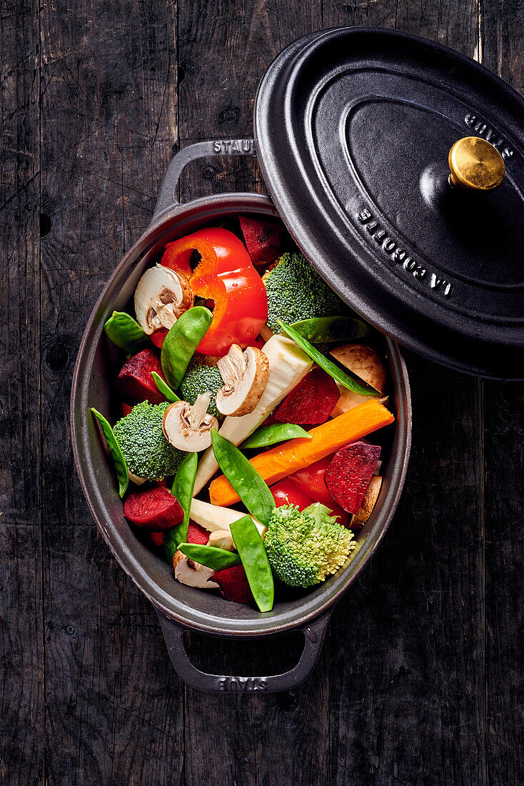 Mixed raw vegetables in a cocotte pot (top view)