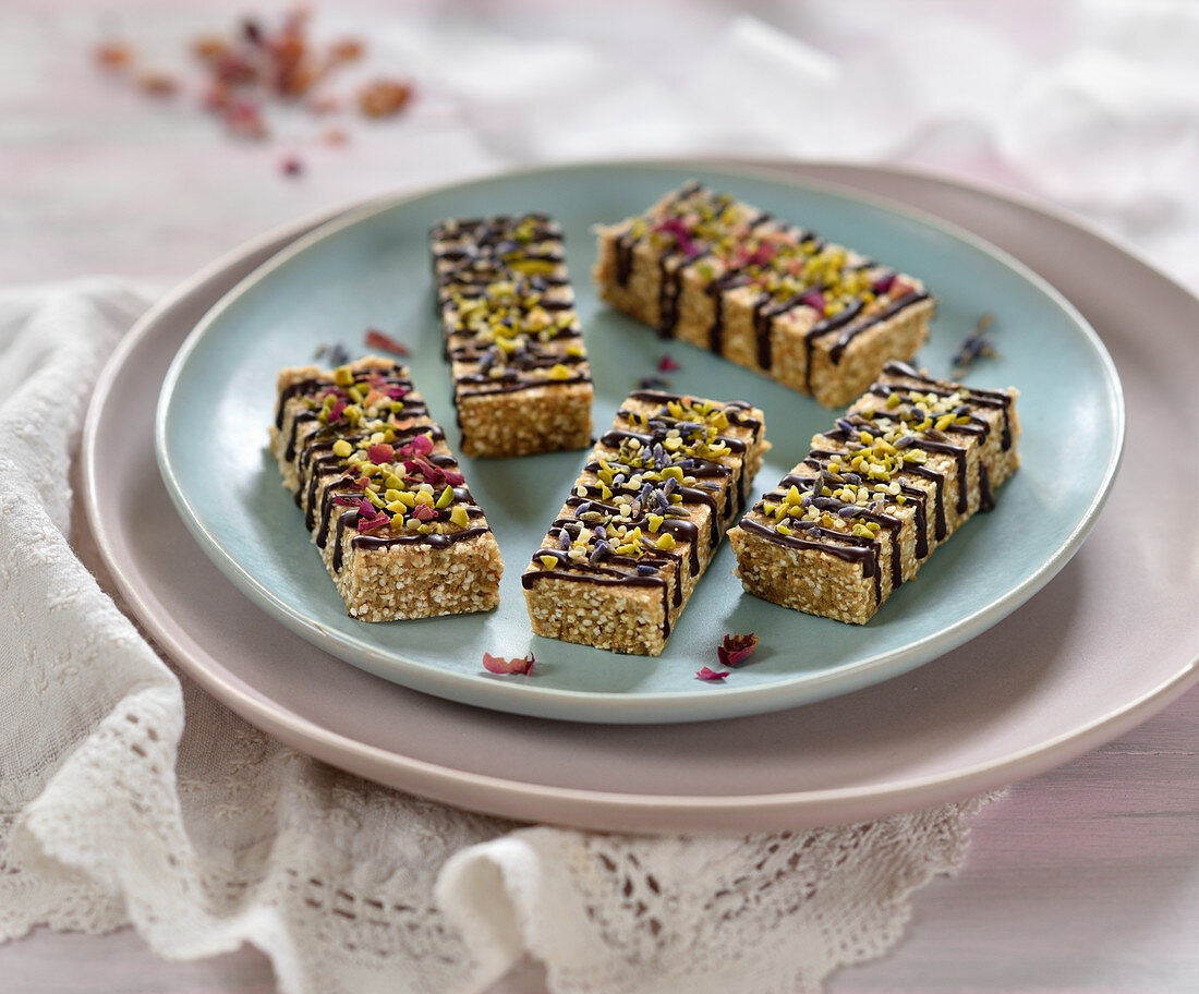 Vegan amaranth and almond bars with chocolate, dried flowers, pistachios and hemp seeds