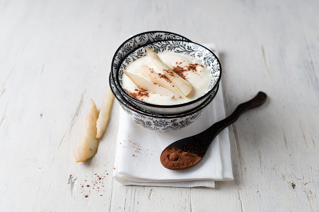 Joghurt mit Birnenscheiben und Kakaopulver