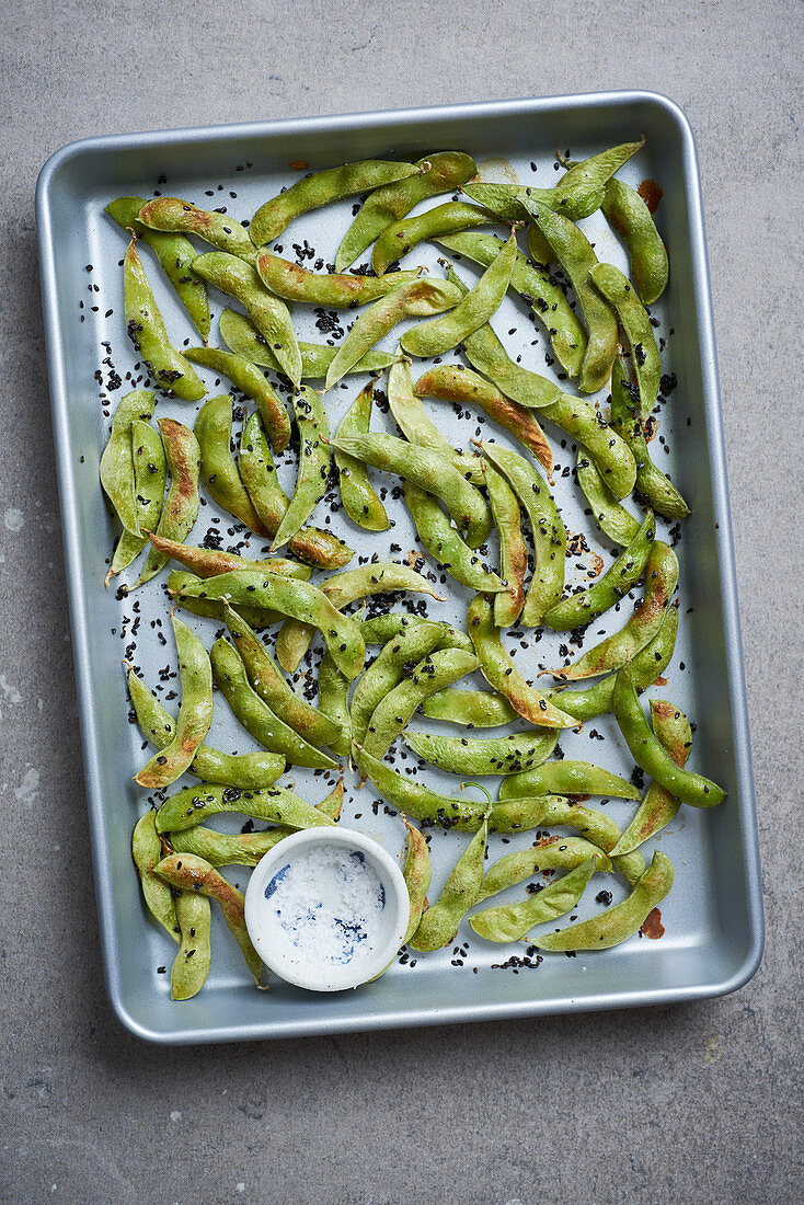 Edamame with salt and black sesame seeds on a baking sheet (Japan)