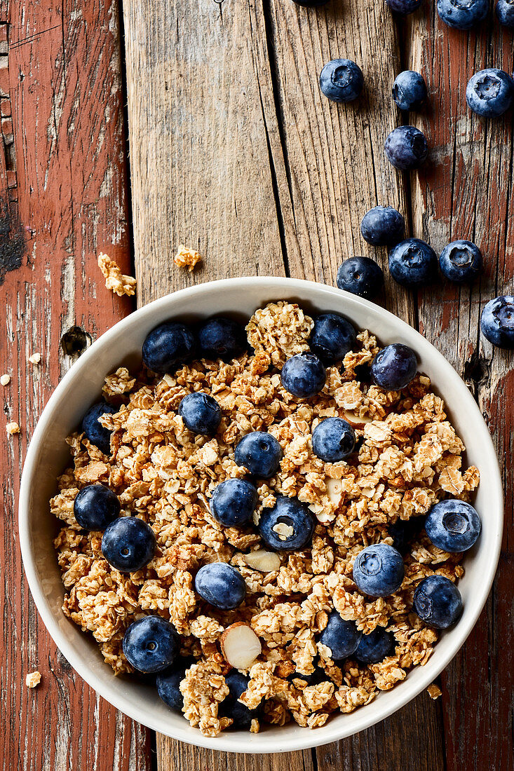 Granola with fresh blueberries in a small bowl (top view)