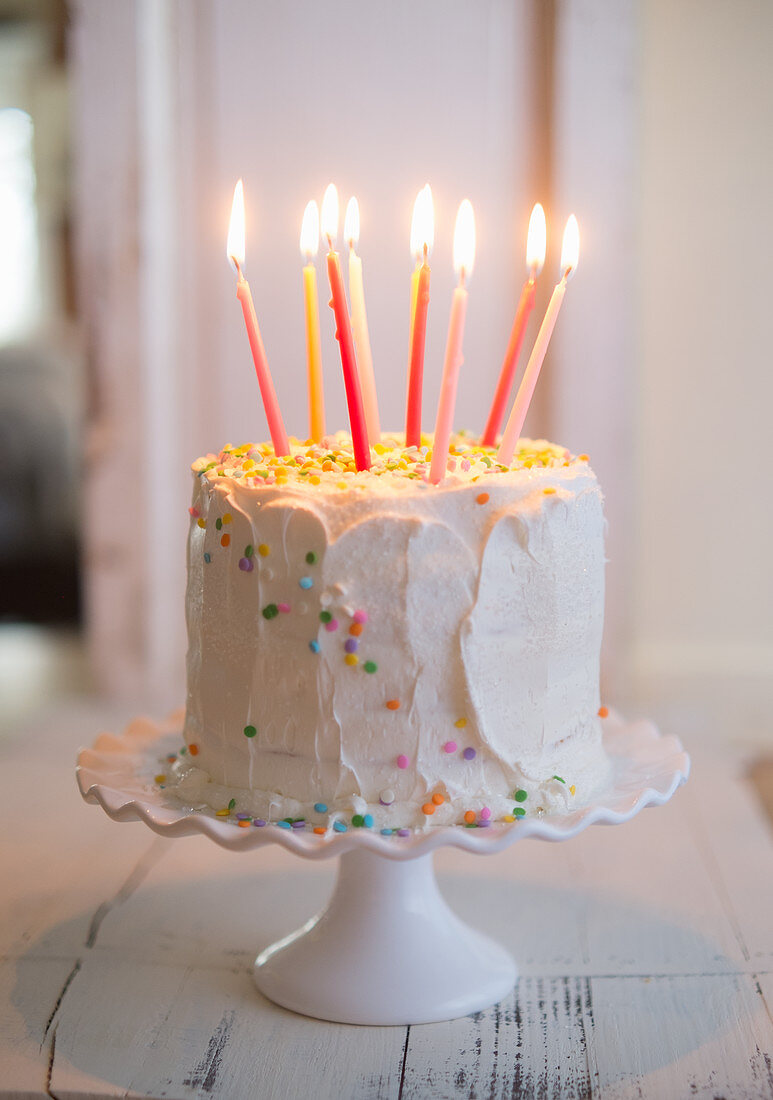 weiße Geburtstagstorte mit Zuckerkonfetti und Kerzen