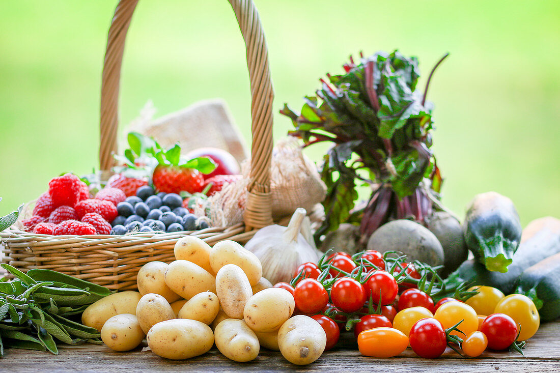 Sommerliches Obst und Gemüse im Korb und daneben