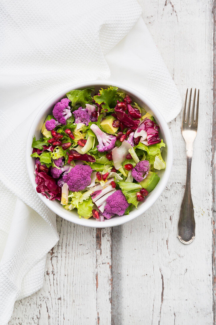 Gemischter Blattsalat mit lila Blumenkohl, Avocado und Granatapfelkernen