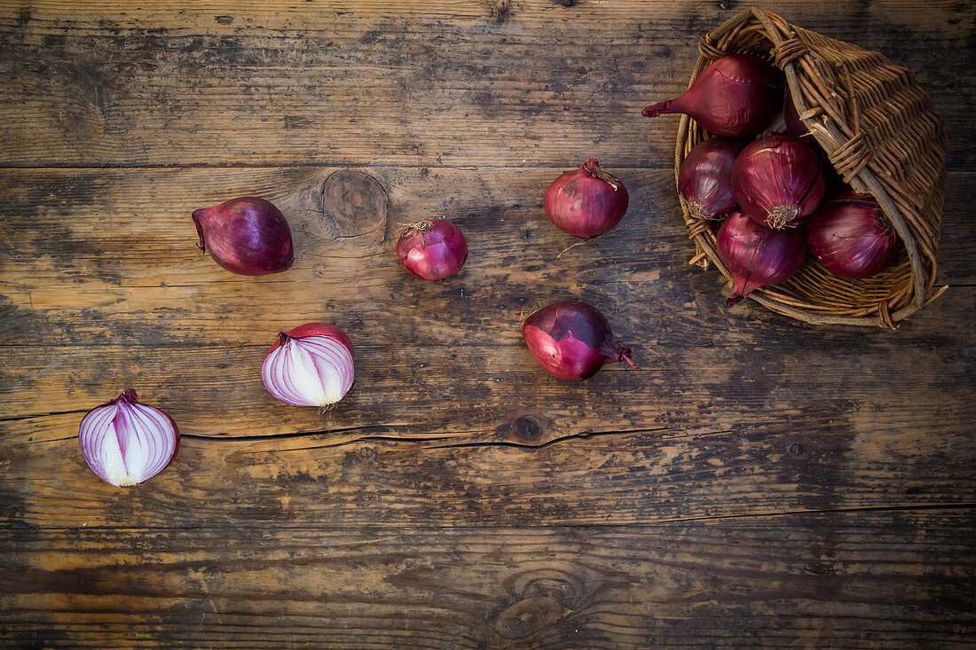 Red organic onions in a basket and in front of it