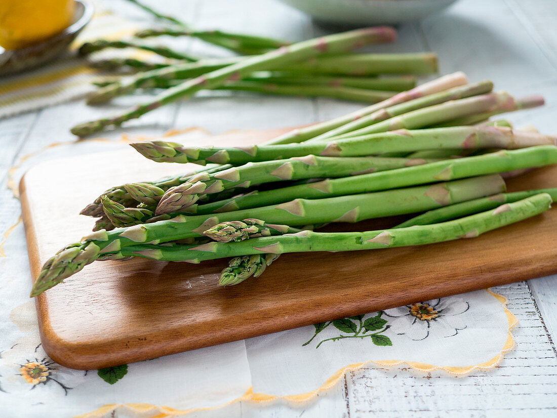 Raw green asparagus on cutting board