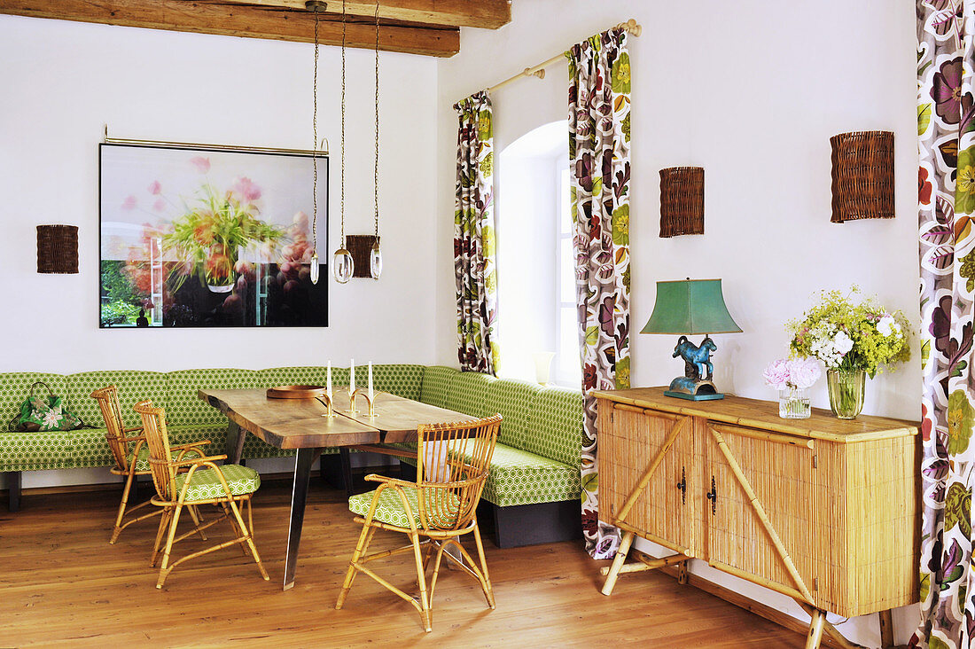 Green corner bench and rattan furniture in dining room with Oriental ambiance