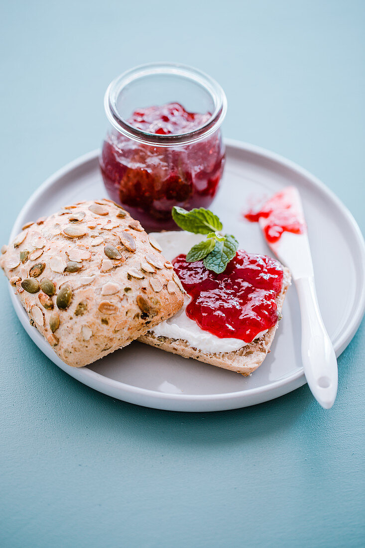 Quark and strawberry jam on a bread roll