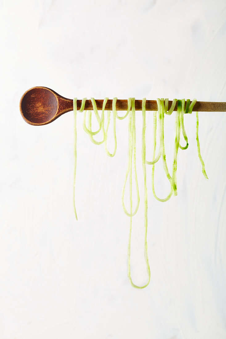 A long zoodle around a wooden spoon