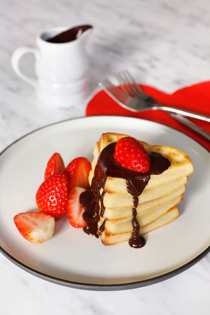 Valentine waffles with strawberries and chocolate sauce