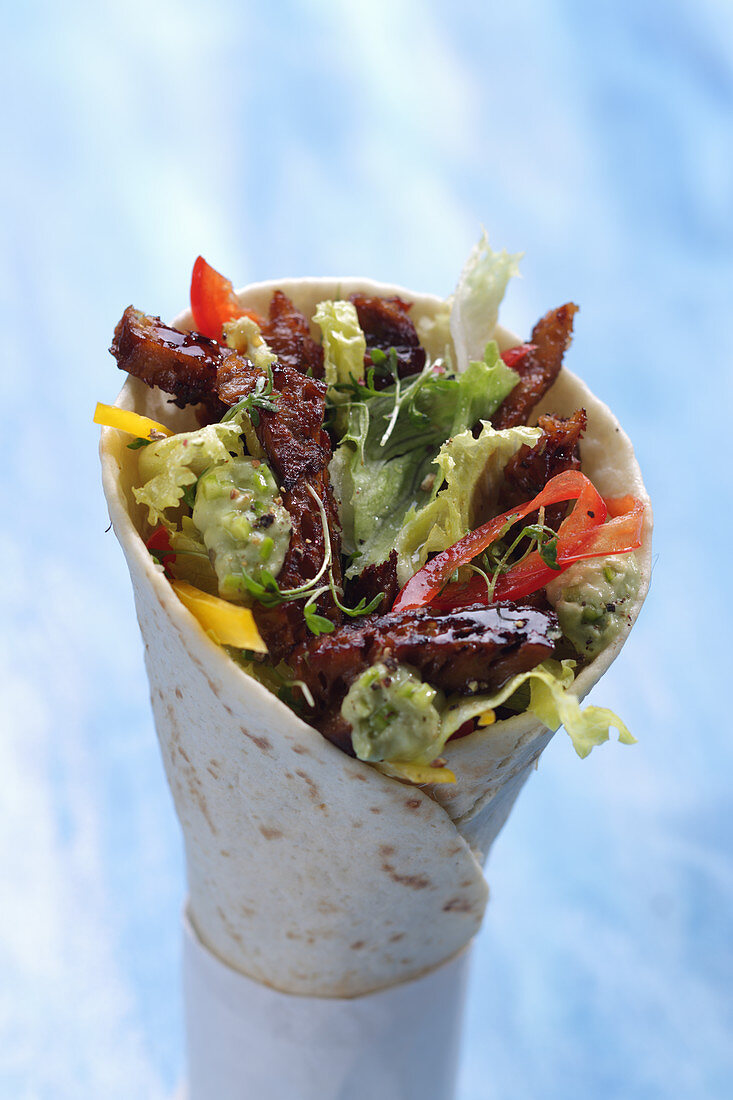 A seitan wrap with vegetables and lettuce