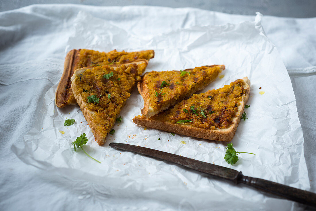 Gegrillte Toastscheiben mit veganem Kichererbsen-Curry-Hack