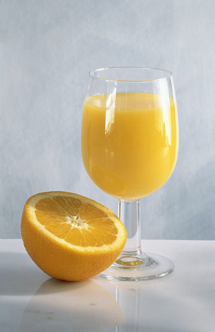Ein Glas Orangensaft & eine halbe Orange
