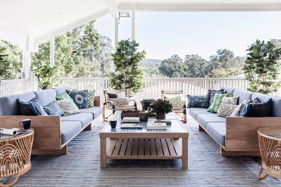 Sofas mit Kissen und Couchtisch auf überdachter Terrasse