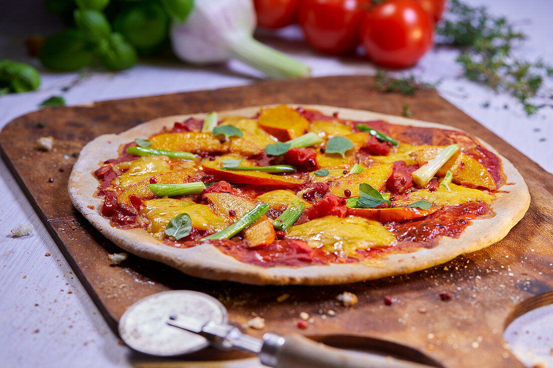 Vegetable pizza with pumpkin on a pizza paddle