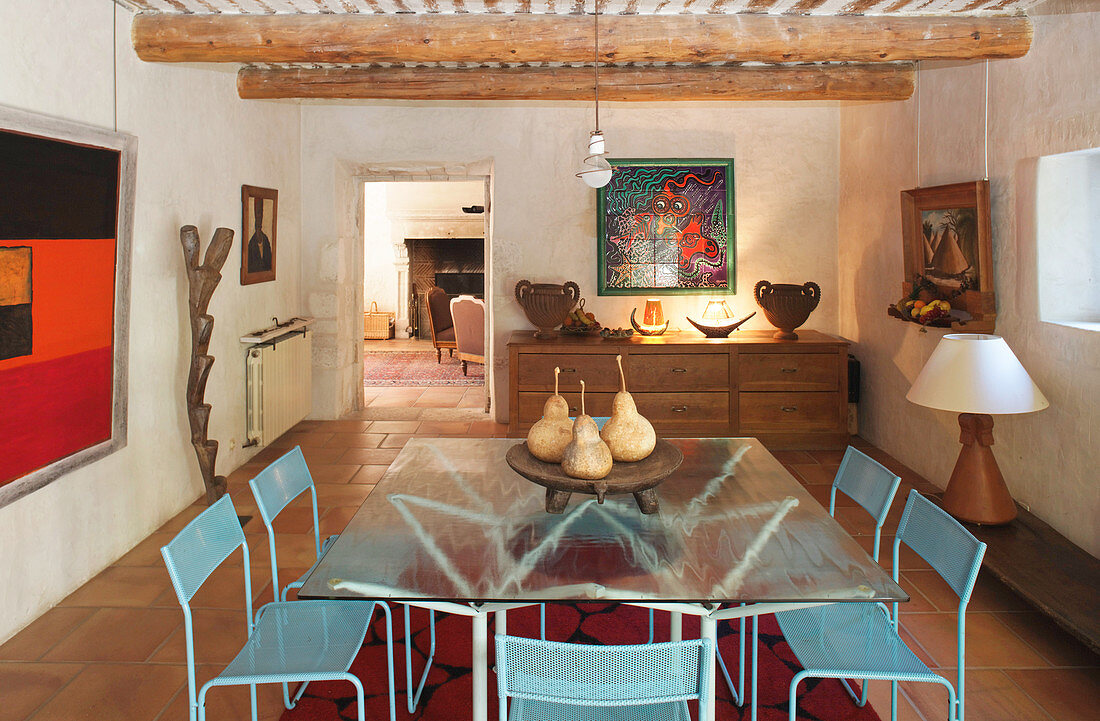 Glass table and blue metal chairs in dining room