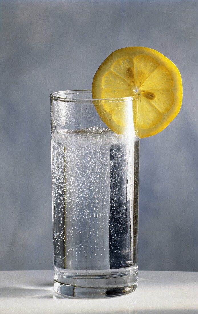 Ein Glas Mineralwasser mit Zitronenscheibe