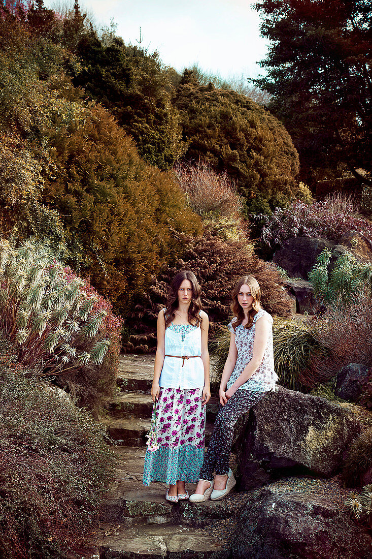 Two young women in a park wearing floral patterned outfits