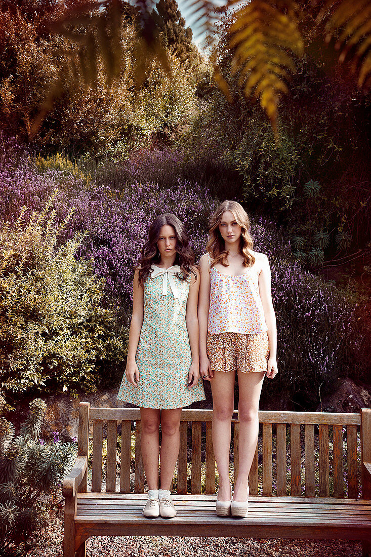 Two young women in a park wearing floral patterned outfits