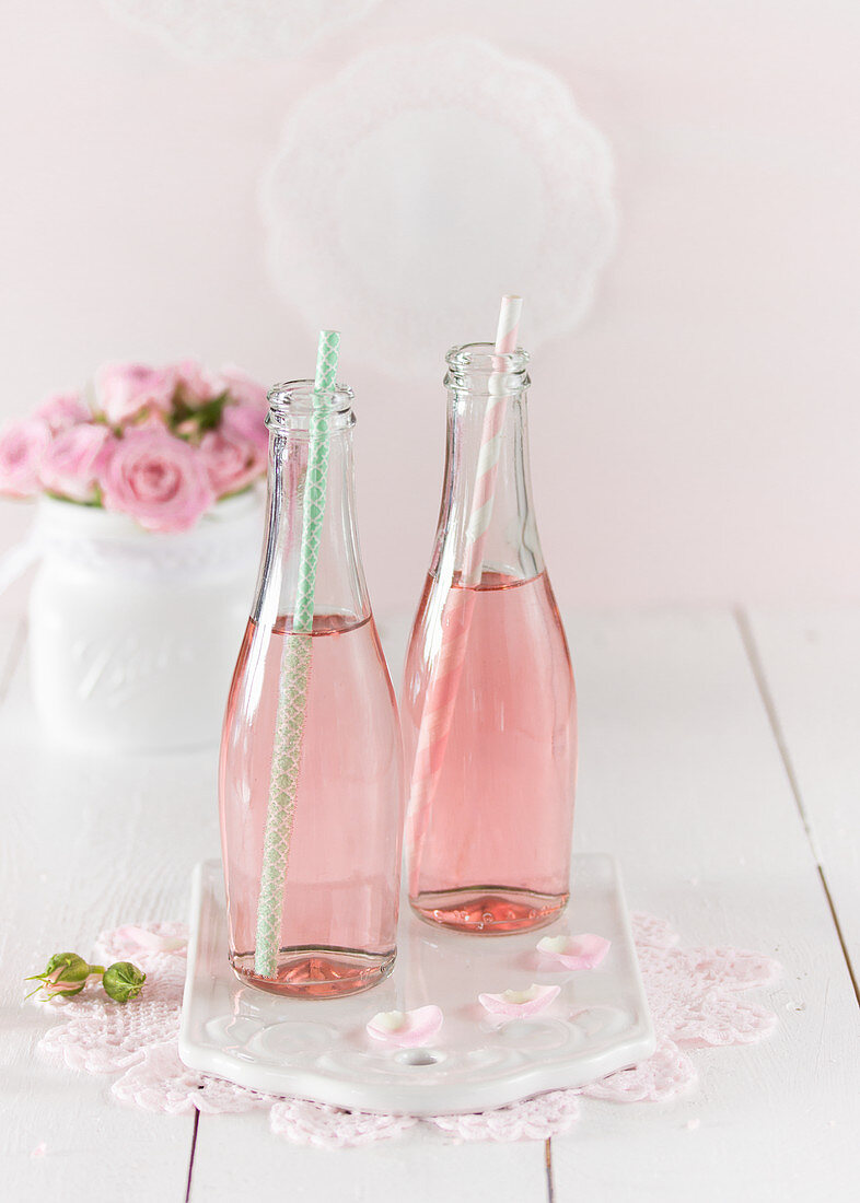 Two bottles of pink prosecco with straws