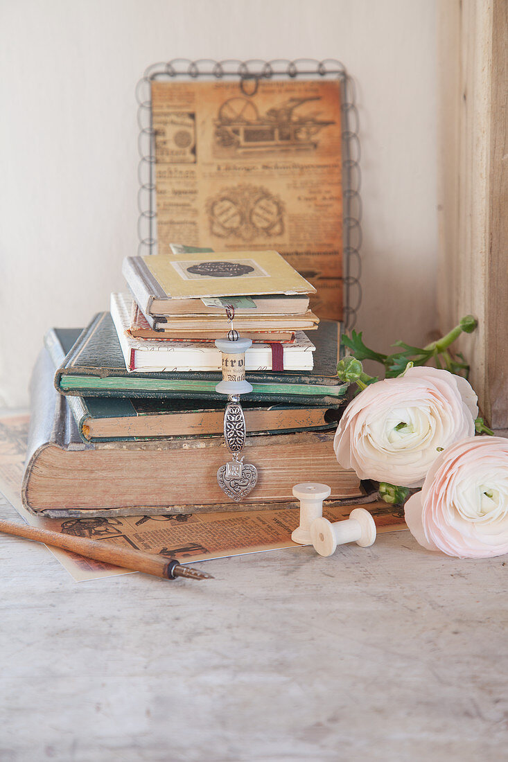 Bookmark with pendant made from old yarn reel and stack of old books