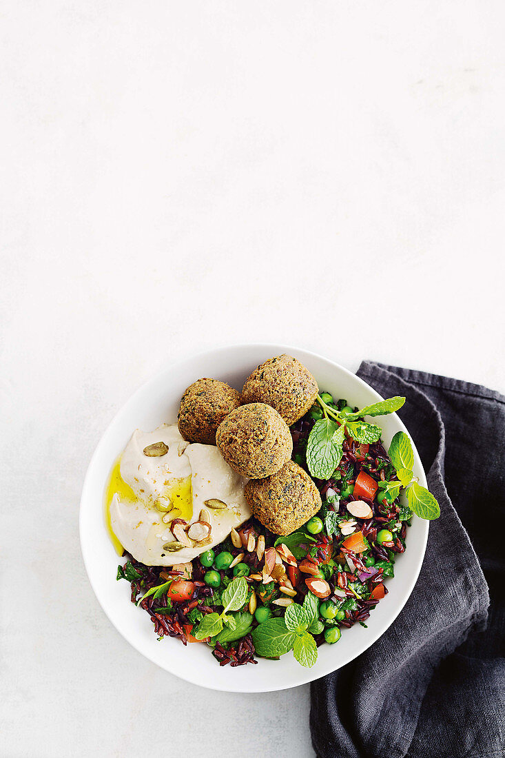 Falafel und pochiertes Ei auf Tabouleh mit schwarzem Reis