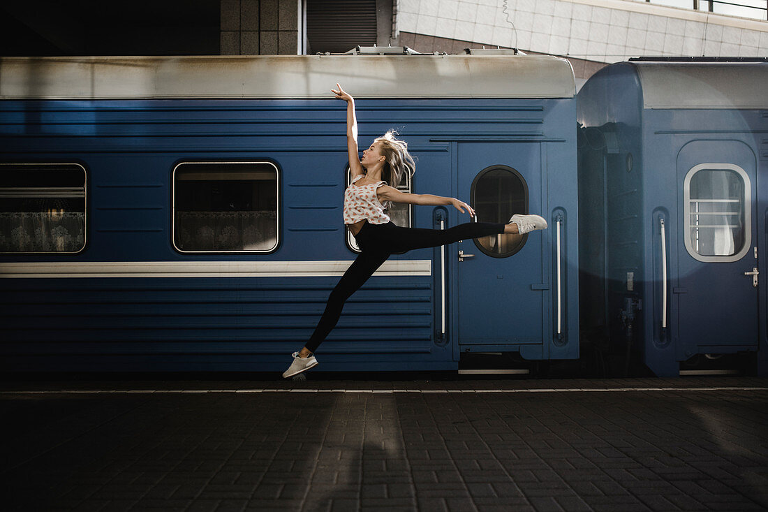 Caucasian woman dancing near train