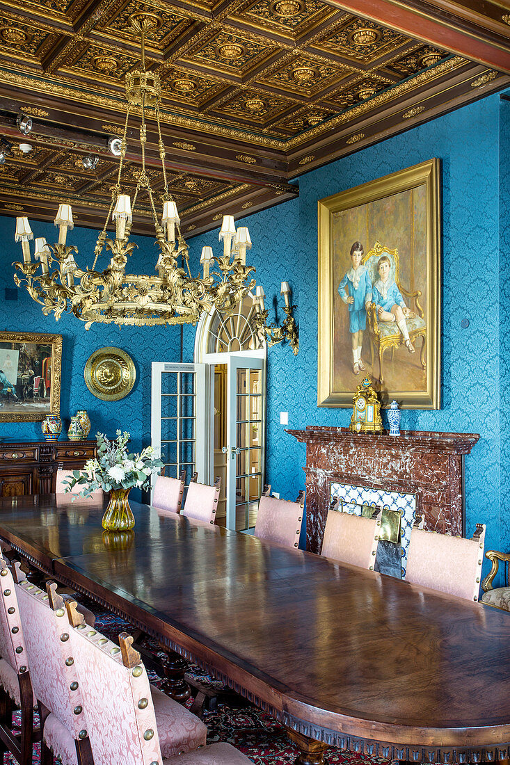 Opulenter Speisesaal mit langer Tafel und Kassettendecke