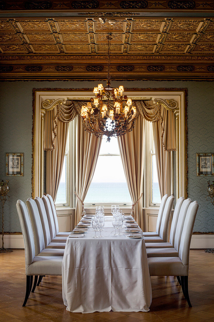 Precisely positioned upholstered chairs around long dining table in classic dining room