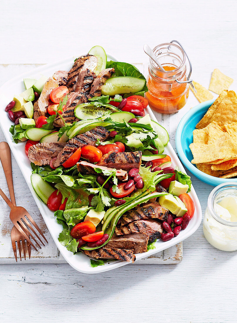 Nacho-Salat mit Rindersteak, Avocado, Gurken, Tomaten und Kidneybohnen
