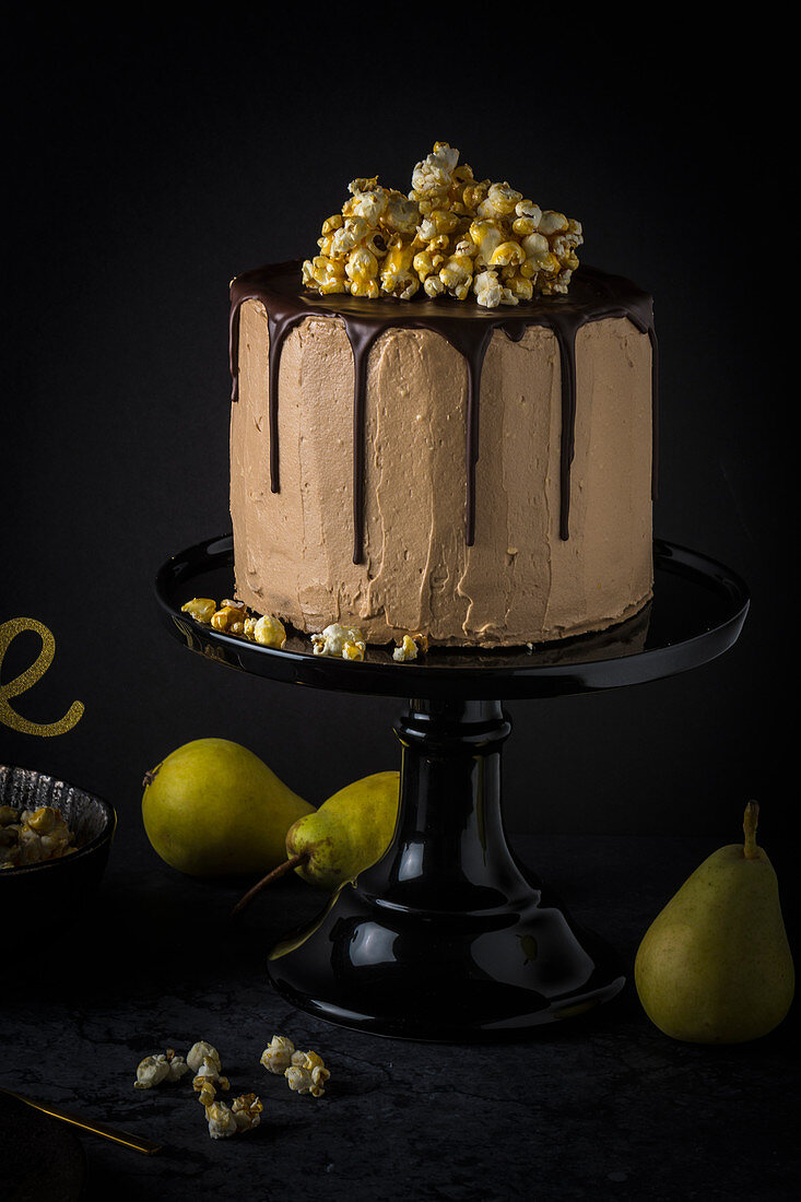 Birnen-Nougat-Torte mit Karamell-Popcorn auf schwarzer Tortenplatte