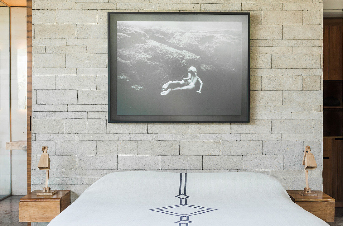 Double bed, black and white photograph above, and bedside tables in the bedroom