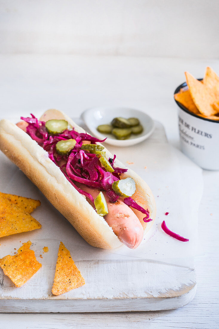 A hot dog with pickled red cabbage and gherkins