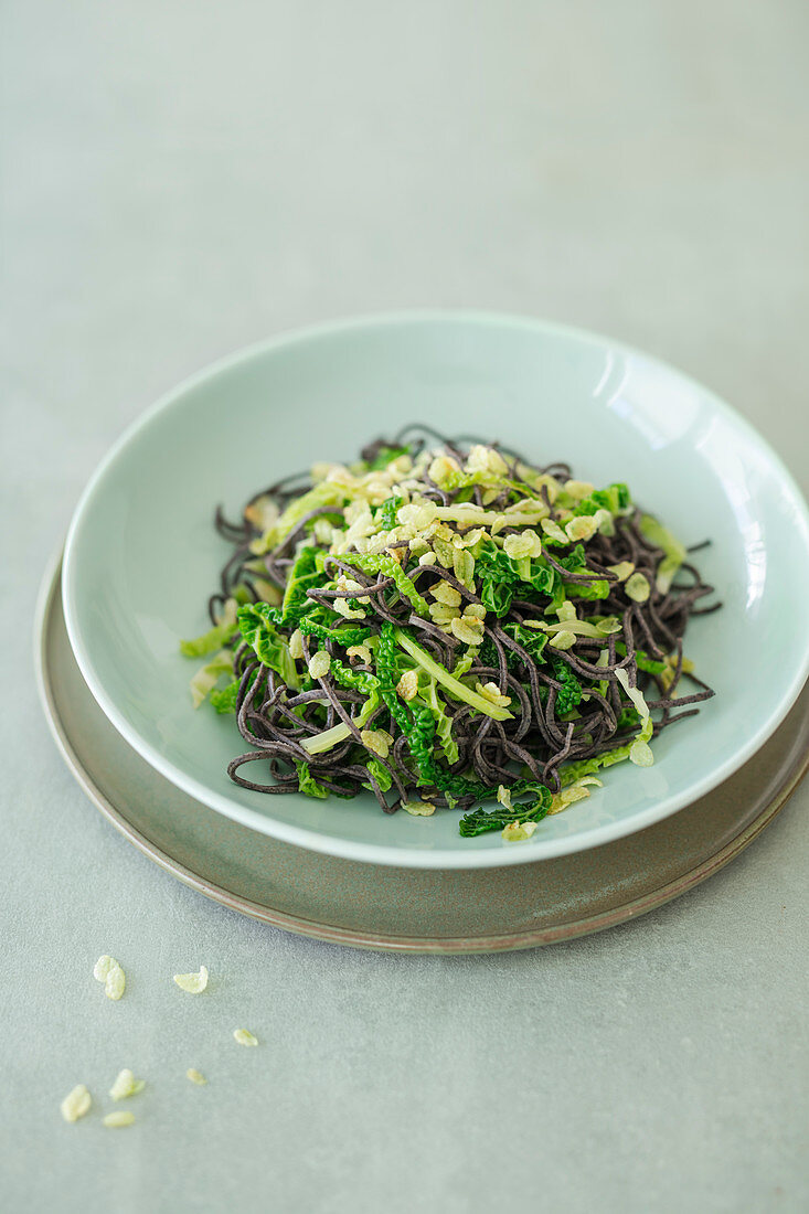 Schwarze Bohnennudeln mit Wirsing und frittiertem grünem Reis (vegan)